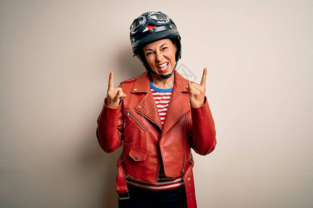 中年骑摩托车的女人戴着摩托车头盔和夹克图片