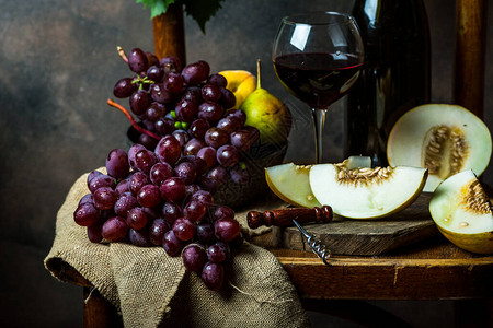 瓶子和一杯红酒葡萄和软木塞在椅子上图片