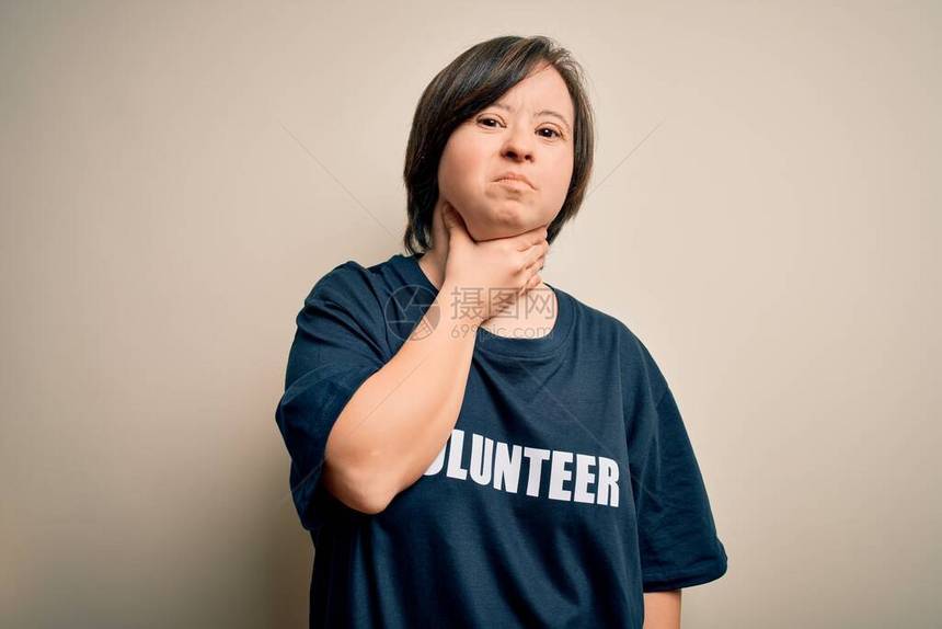 年轻的唐氏综合症志愿者妇女穿着社会关怀慈善T恤触摸颈部疼痛喉咙痛流感图片