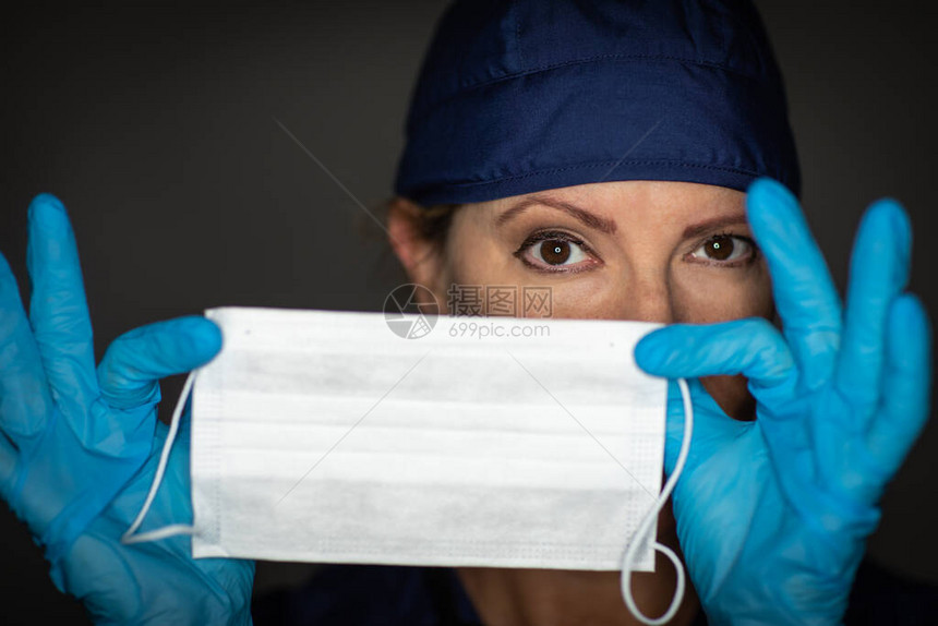 女医生或护士穿外科手套戴医疗面罩的图片