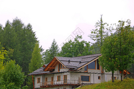 看见山上一座房屋正在兴建中在雾密的清晨云彩的背图片