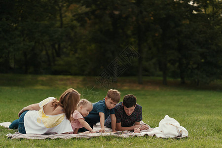 快乐的一对年轻夫妇在大自然中与女儿和子一起户外玩耍图片