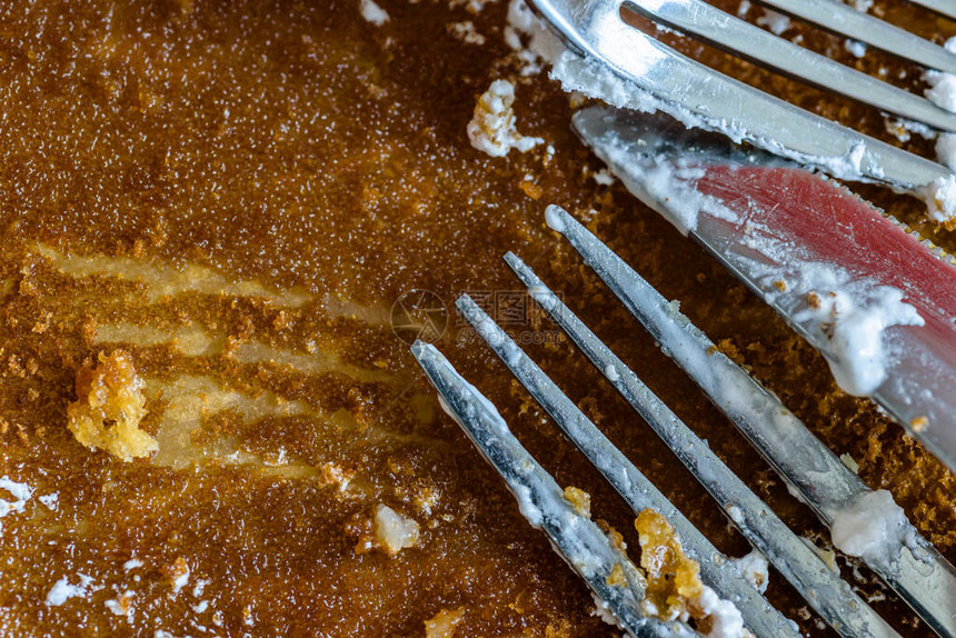 叉刀和勺子上面盖着苹果派在空的烘烤纸图片