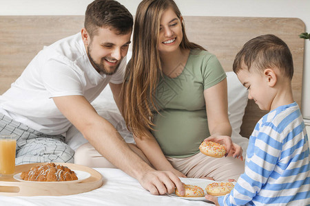 在卧室吃糕点的幸福家庭图片