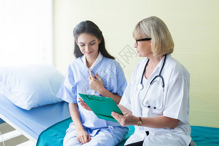 医生和病人的女人在医院病房里讨论一些保图片