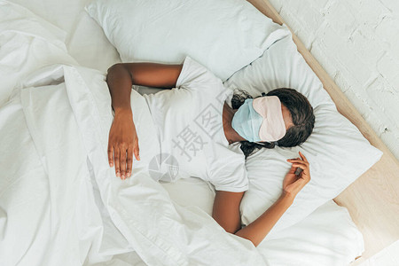 睡着面具和在床上睡觉的医用面罩上图片