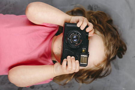 小女孩摄影师带着相机笑着拍照图片