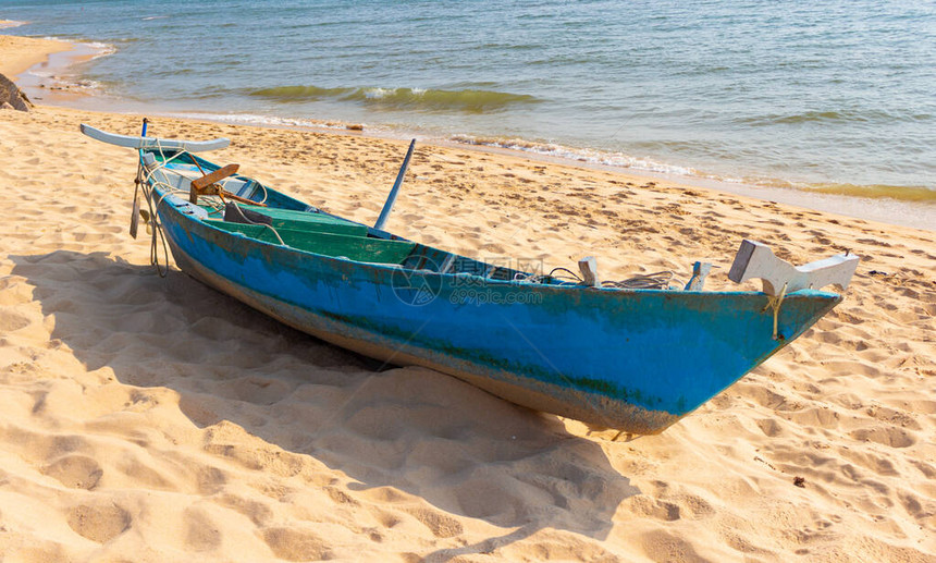 在沙滩上弃置的渔船热带海滩上的图片