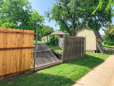 美国德克萨斯州达拉斯郊区住宅后院倒塌的旧板条附近的新木栅栏新的隐私图片