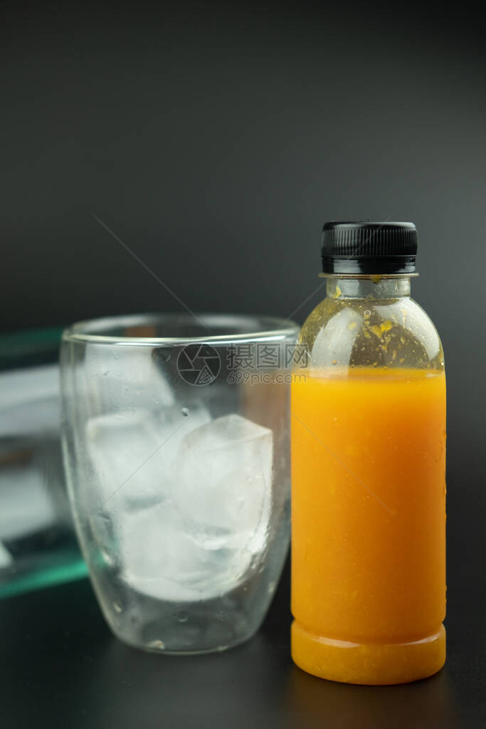 橙汁塑料瓶玻璃中有冰块图片