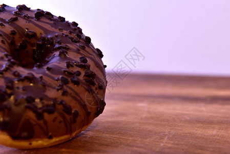 巧克力甜圈在木制桌子上撒着图片