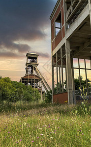 比利时老煤矿井筒的废弃煤矿坑口绕组齿轮与戏剧日落高清图片