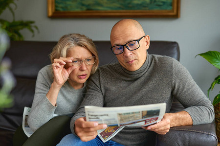 成人妇女和男子阅读报纸新闻报刊媒体节假图片