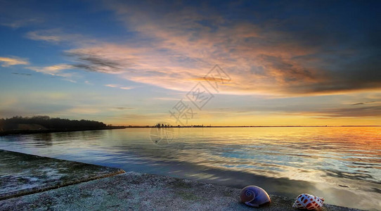 海蓝色浪漫金色粉红色多云天空橙色天际线海景的日落图片