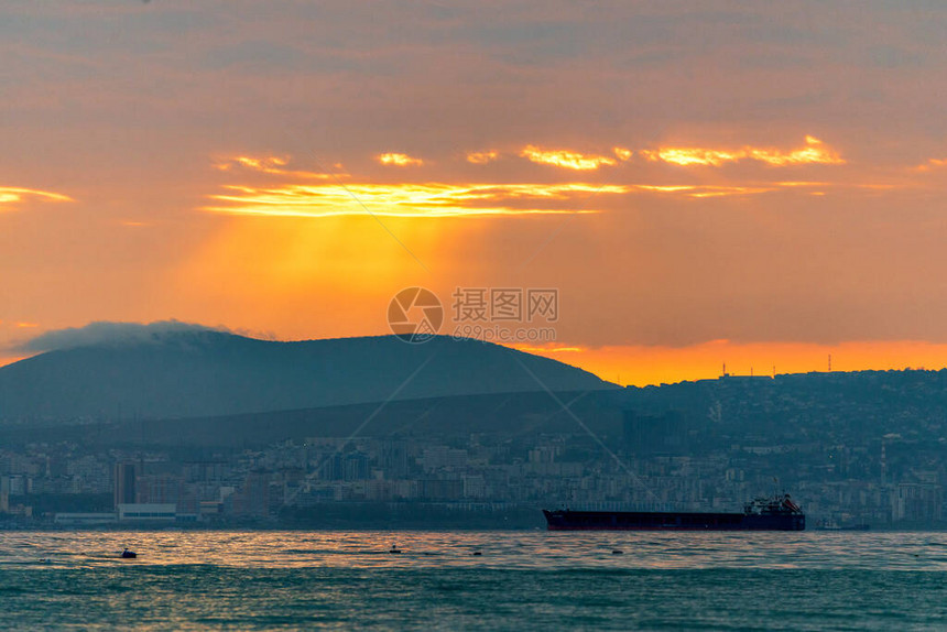 货船在的日落或日出时在海上航行太阳落山或升起时跨水海运大自然的和谐与美丽风景秀图片