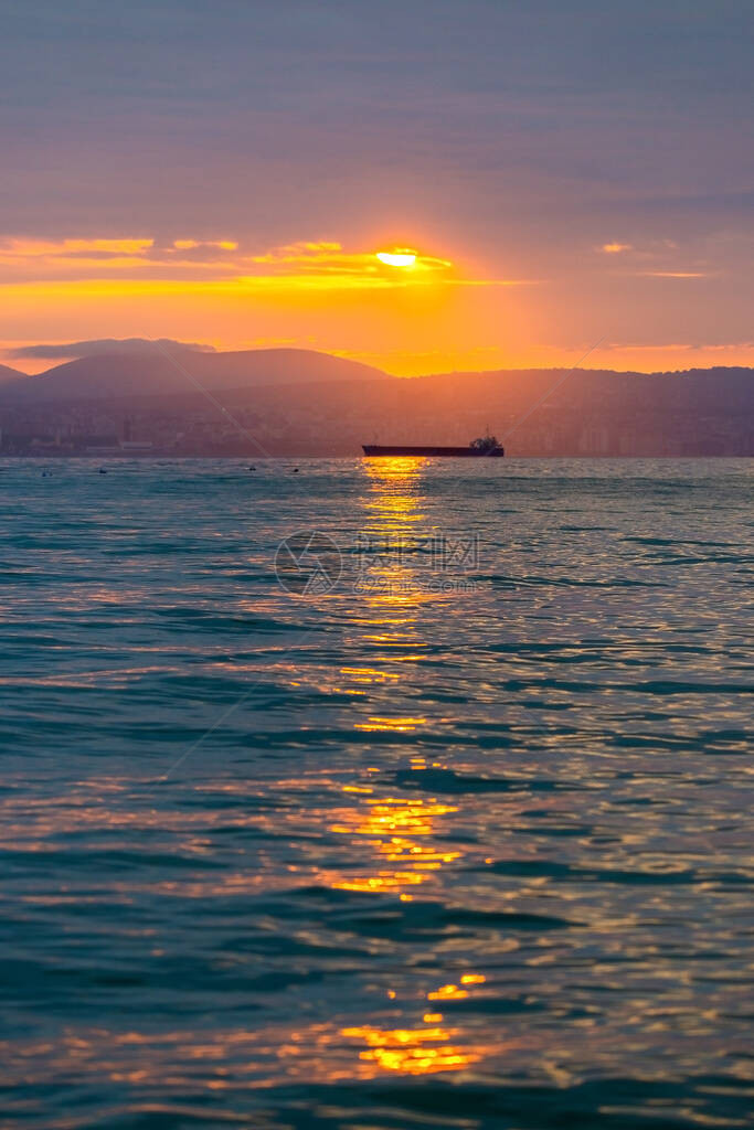 货船在的日落或日出时在海上航行太阳落山或升起时跨水海运大自然的和谐与美丽风景秀图片