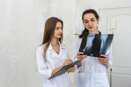 医生在医院对病人的X光检查进行年轻实习生分析图片