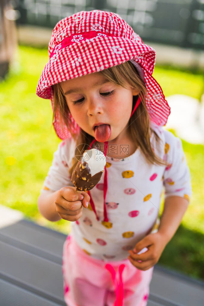 小孩在棍子上吃冰淇淋在后院的小女孩带图片
