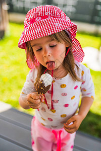小孩在棍子上吃冰淇淋在后院的小女孩带图片