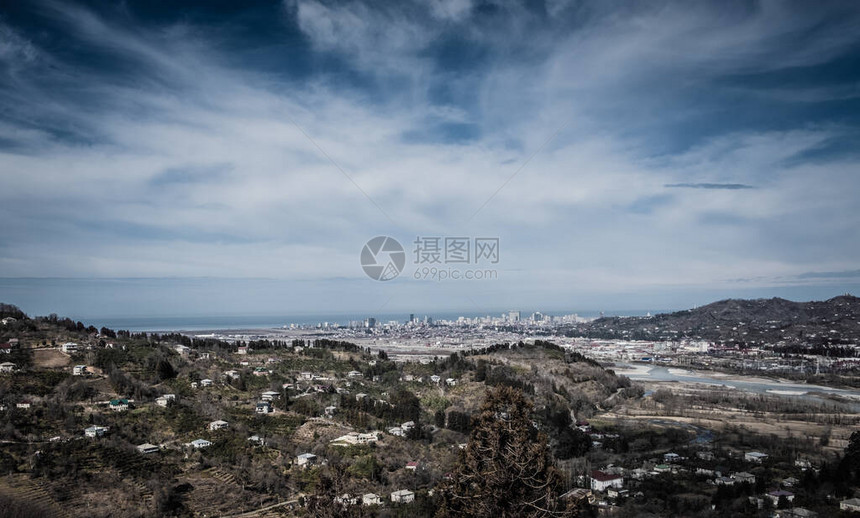 高加索山脚下的景色巴统市的区高处有雪在较低的山上是住宅楼地球有不同的颜色从高处看山的全图片