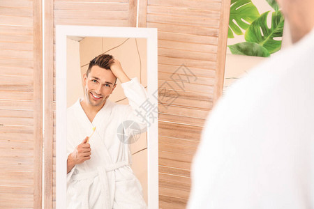 英俊的年轻人用牙刷照镜子图片