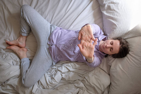 女瑜伽女人早上在床上做苏普塔巴迪达科纳萨图片
