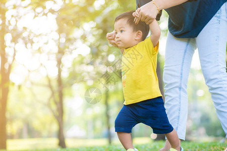 男孩在城市公园日落灯婴儿发育中由妈图片