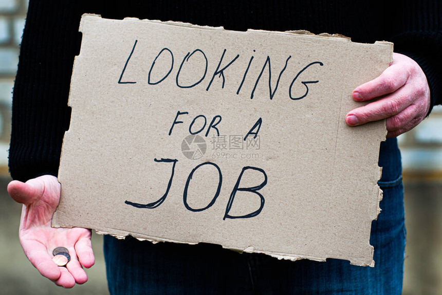失业者手里拿着一块写有找工作字样的纸板图片