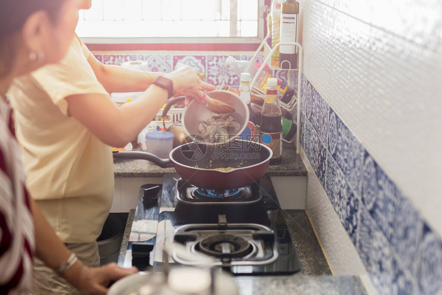 亚洲妇女在厨房做饭时图片