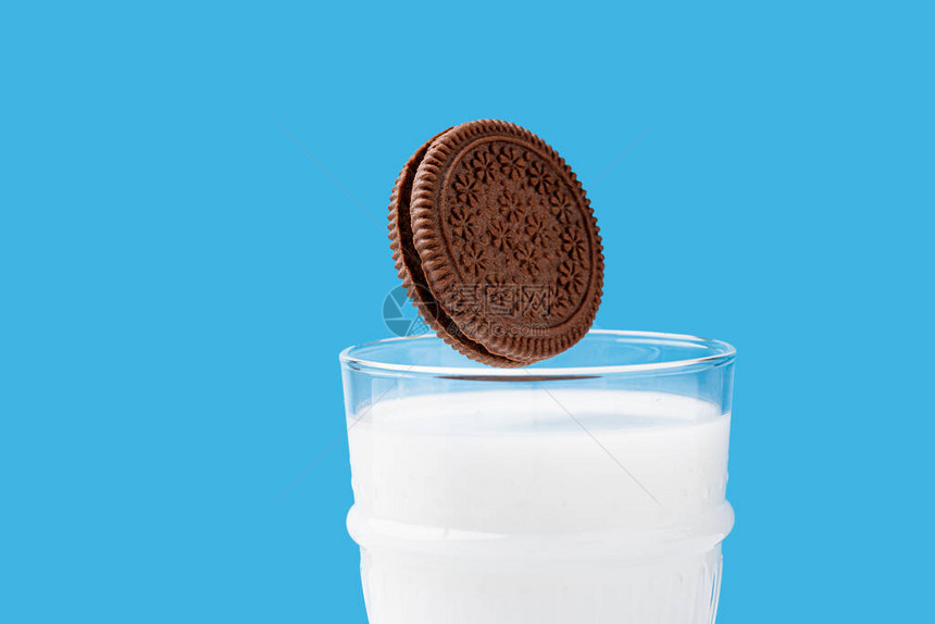 在一杯牛奶中加入奶油滴巧克力曲奇图片