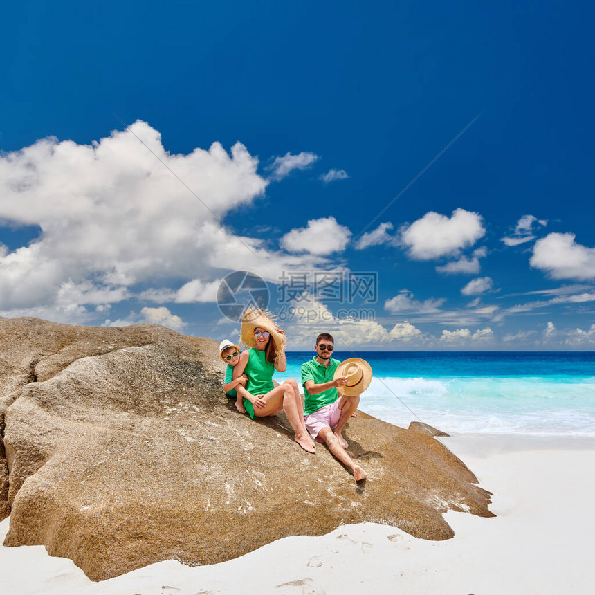 一家人坐在美丽的AnseIntendance海滩上的岩石上图片