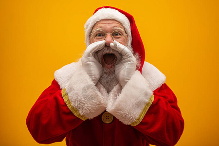 张开嘴巴的兴奋风趣时尚的圣诞老人握着手掌靠近脸图片