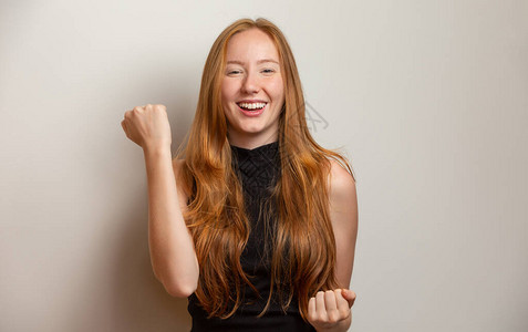 快乐的红发女孩庆祝惊人的消息图片