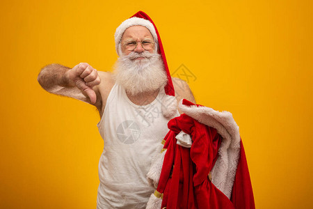 不开心的圣诞老人在送礼物之后或之前拿着他的衣服圣诞老人的衣服戏图片