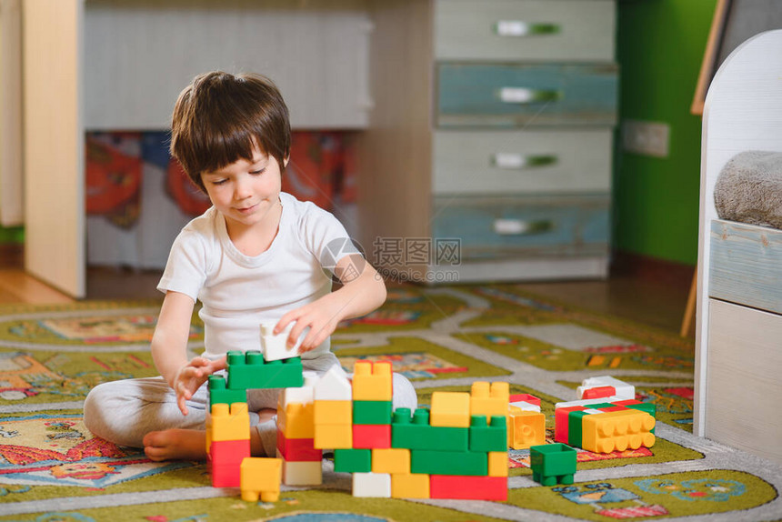 可爱的小男孩在家里玩建筑立方体图片