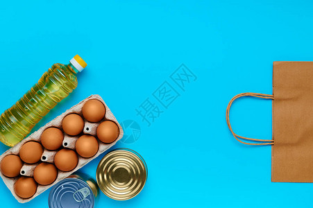 鸡蛋罐头食品油蓝色背景的纸袋图片