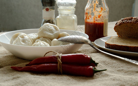 餐桌上有番茄酱辣椒面包和辣椒吃得愉图片