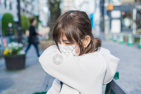 年轻亚洲妇女咳嗽时用手在嘴上咳嗽图片