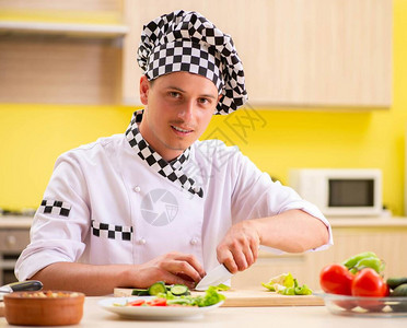 在厨房准备沙拉的年轻专业厨师图片