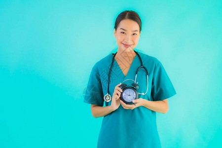 女医生在蓝色孤立背景下显示时钟或警报器在蓝光图片