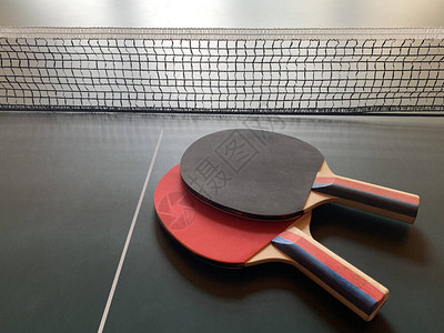 网球桌上的乒乓拍网格背景的桌球篮子概图片