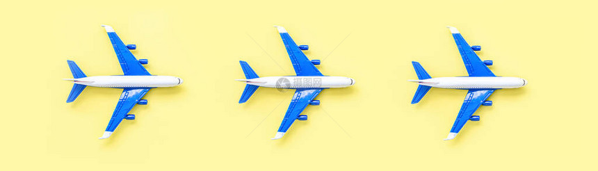 黄色柔和颜色背景上的模型飞机微型玩具飞机顶视图图片