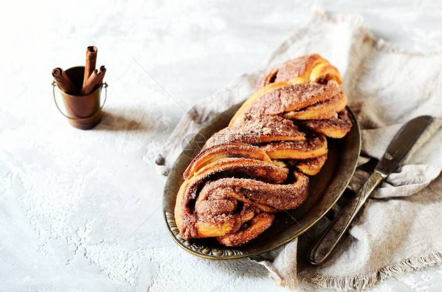 Cinnamon扭曲的面包或黑木背景的烧烤死图片