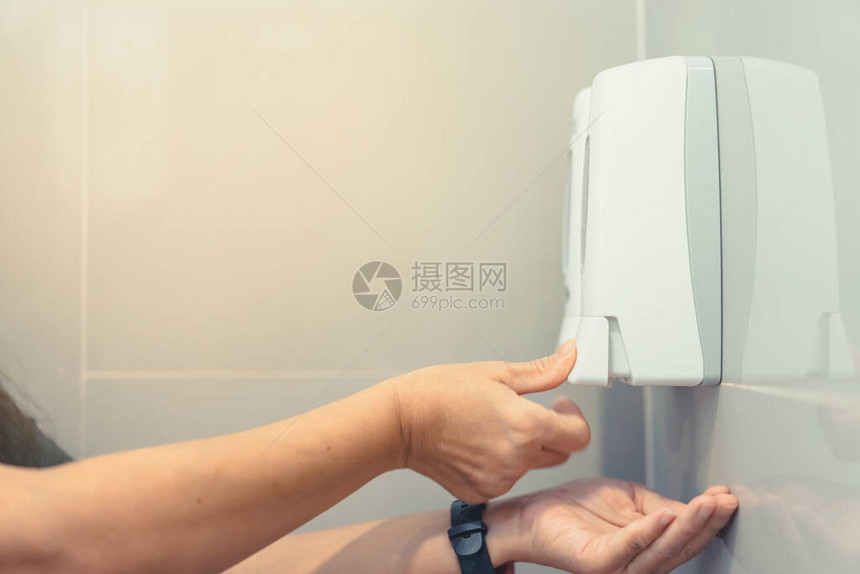 在洗手间里用液体肥皂压机靠近女人的手图片