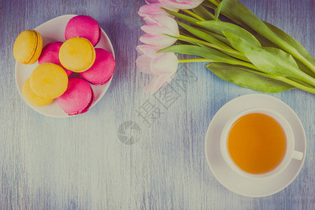 马卡龙茶叶和一束金木背景的郁金香图片