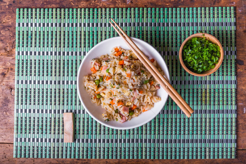 广东大米是传统的炒饭鸡蛋火腿豌豆胡萝卜和香料图片