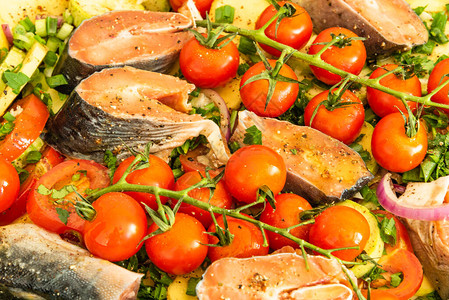 将生蔬菜和鱼块塞在用鳟鱼煮菜烤熟的炖图片