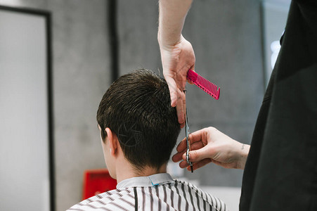 专业理发师在理发店用剪刀客户的头发图片