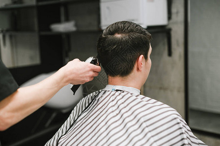 理发师的手用剪刀客户的头发图片