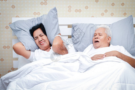 在卧室睡觉的亚洲老年夫妇图片